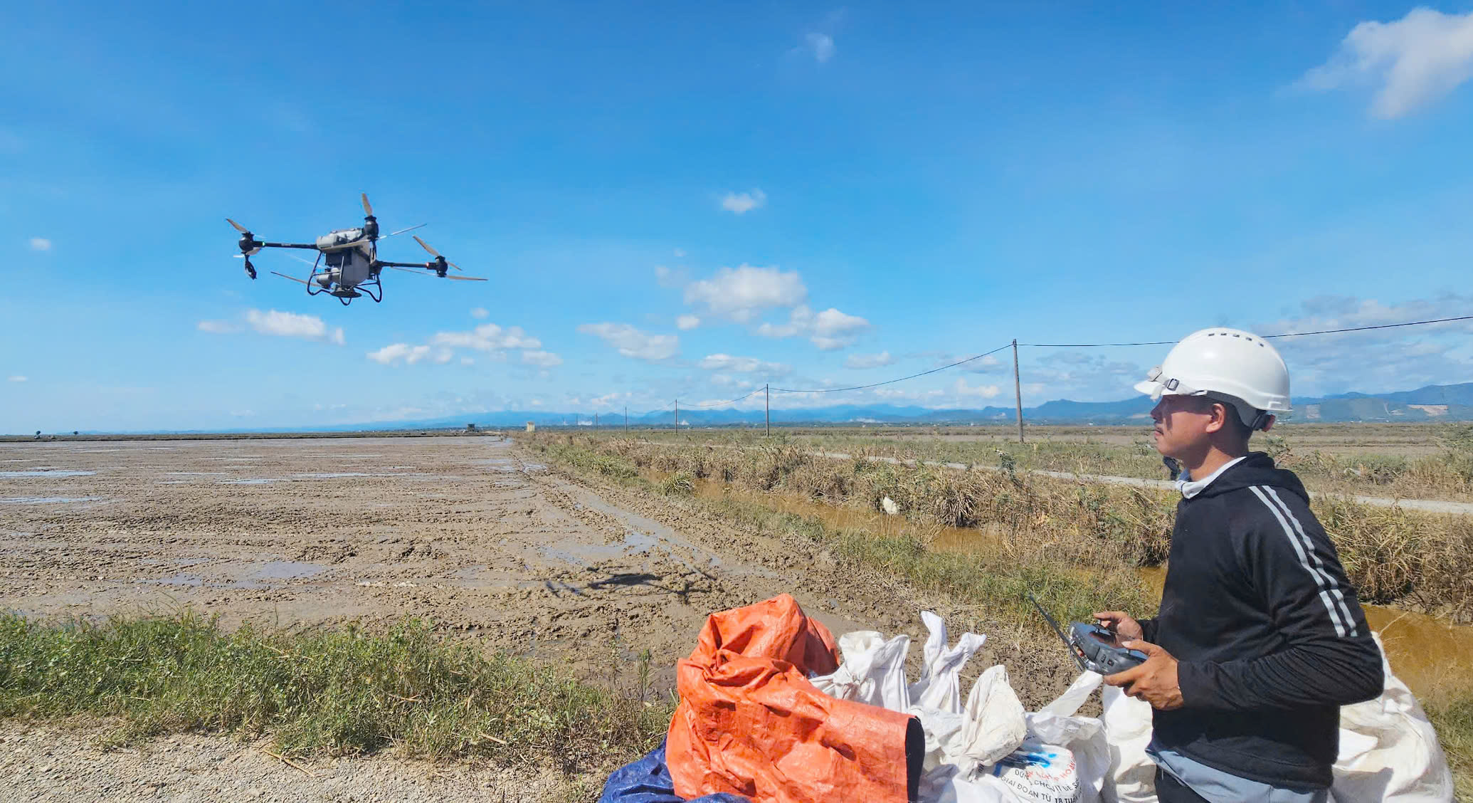 Nhân viên kỹ thuật bay gieo sạ cả trưa để kịp thời vụ. Ảnh: Tâm Đức.