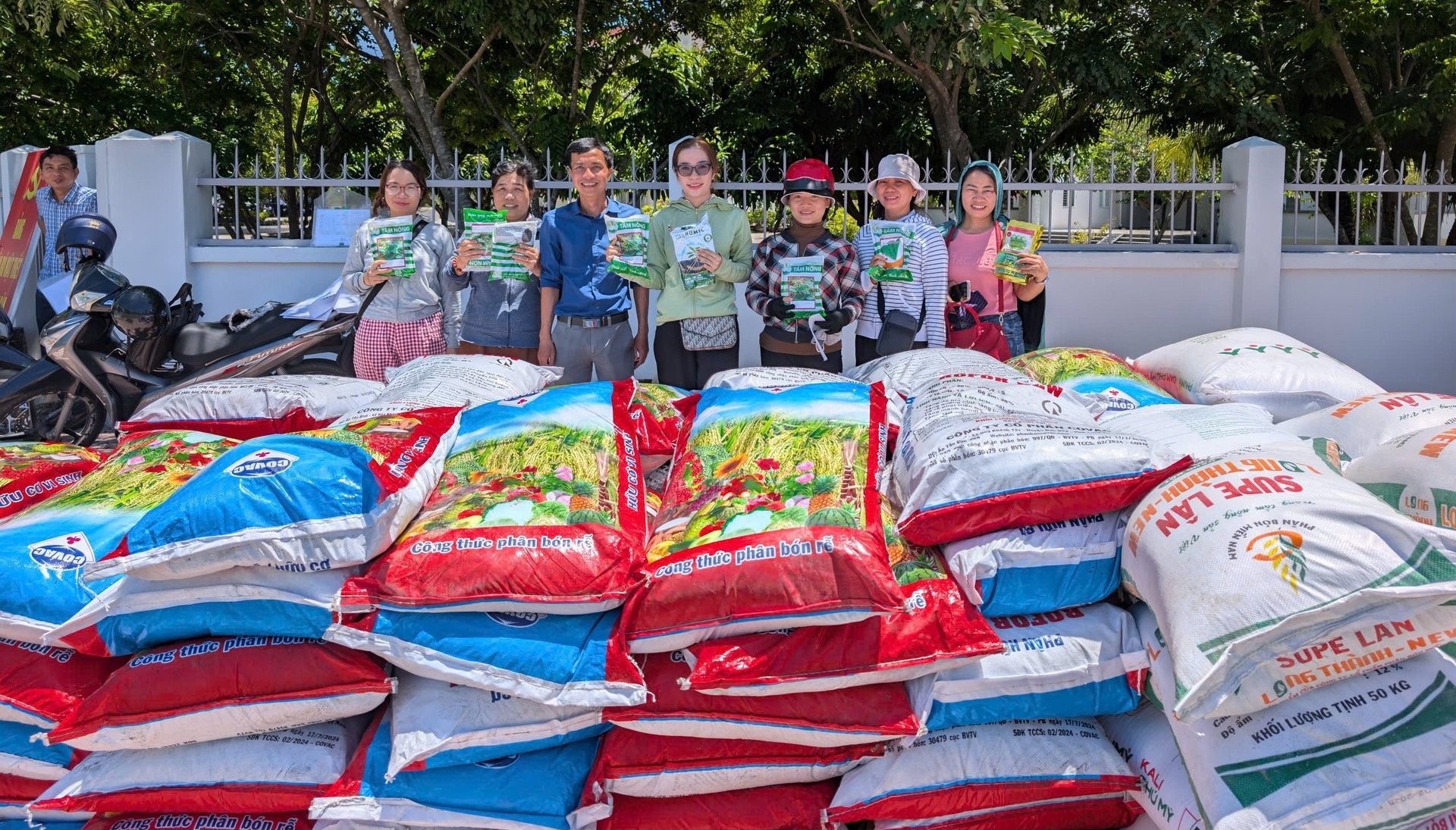 Các hộ dân phường Ninh Hòa nhận vật tư hỗ trợ. Ảnh: Nguyễn Cơ.