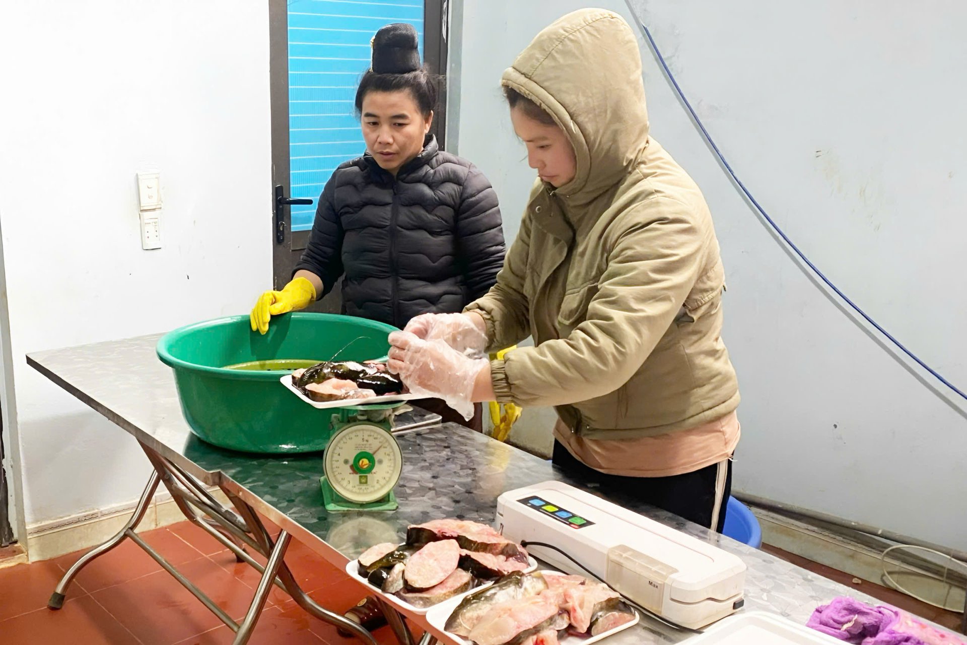 Thành viên HTX An Bình, xã Quỳnh Nhai thực hiện các khâu đóng gói sản phẩm thủy sản cá sông Đà. Ảnh: Nguyễn Nga.