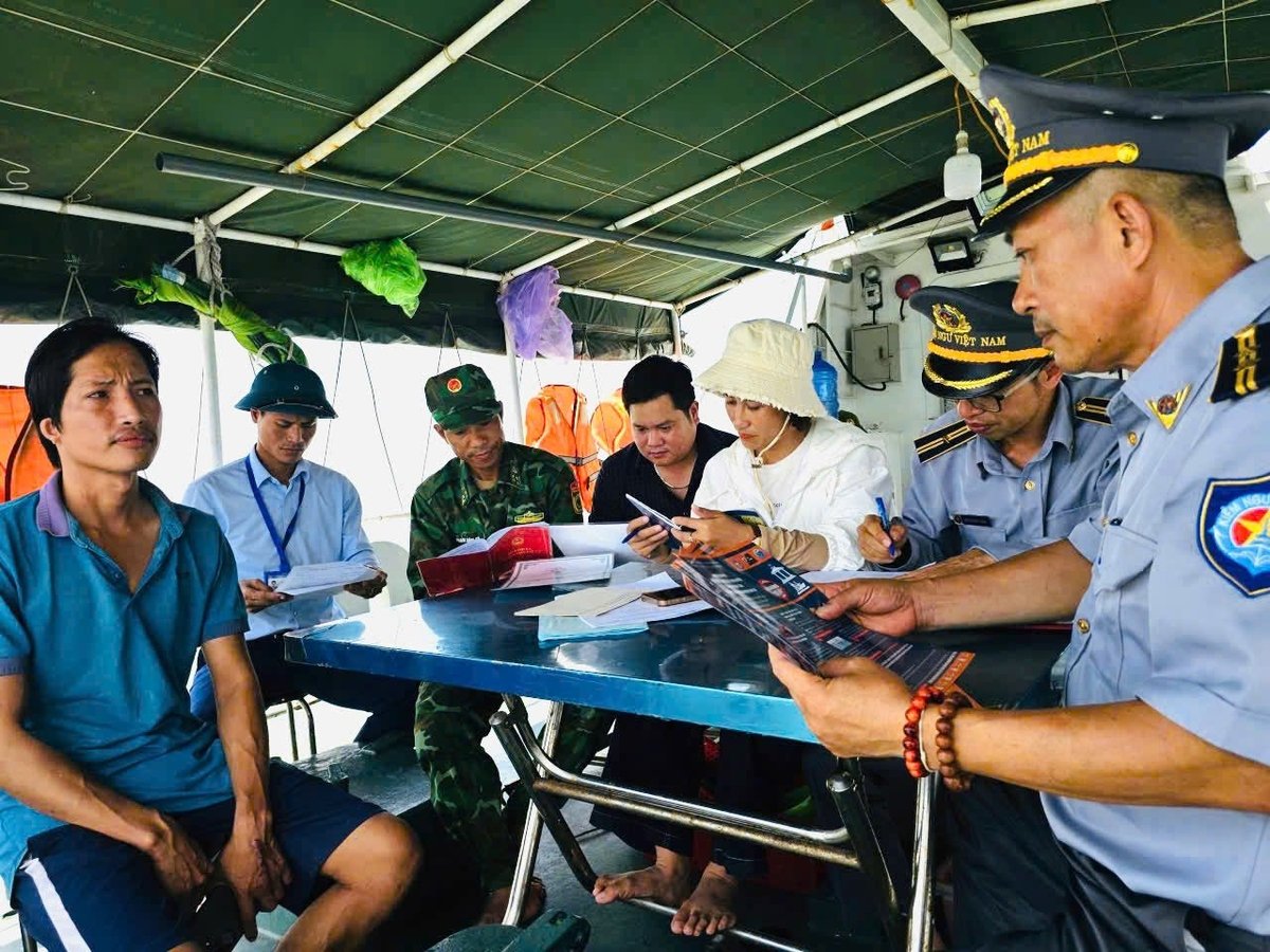 Cán bộ Phòng Kinh tế xã Quỳnh Phú tham gia cùng đòan Kiểm ngư kiểm tra hồ sơ, tuyên truyền cho chủ tàu cá trên biển. Ảnh: Hữu Tình.