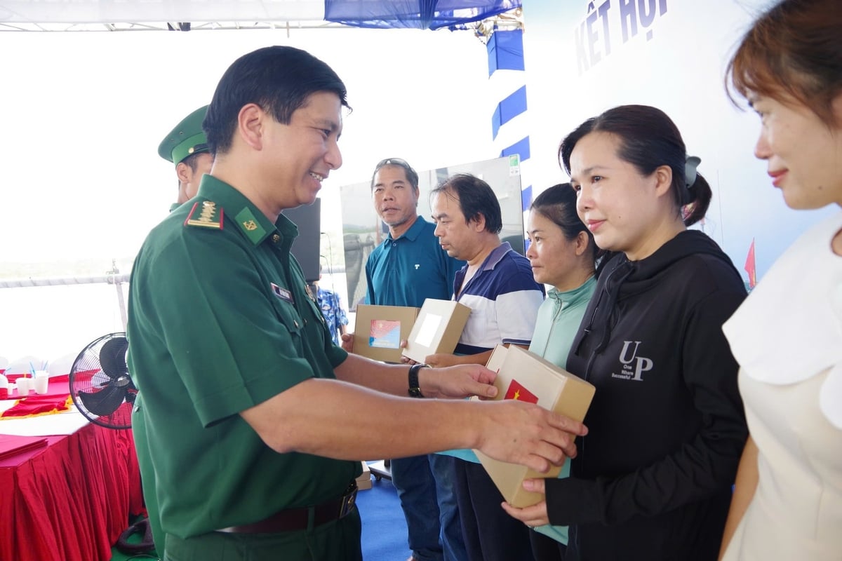 Ban Tổ chức chương trình trao tặng Cờ Tổ quốc và quà cho bà con ngư dân tham dự chương trình. Ảnh: Quang Anh.
