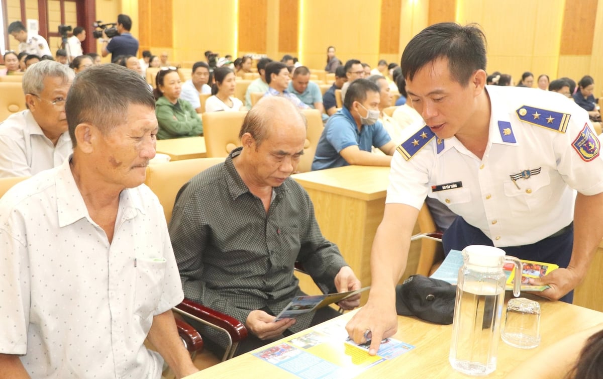Lực lượng cảnh sát biển phát tờ rơi, tờ gấp tuyên truyền về chống khai thác IUU cho các ngư dân. Ảnh: Đức Định.