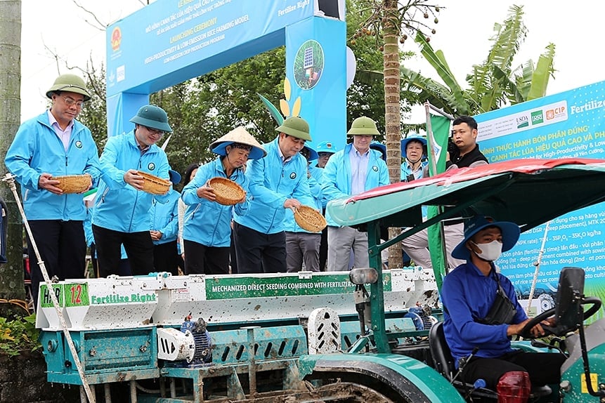 Nguyên Bộ trưởng Bộ NN-PTNT Cao Đức Phát (thứ 4 từ trái sang) cùng các đại biểu thực hiện nghi thức đổ thóc giống. Ảnh: Bảo Thắng.
