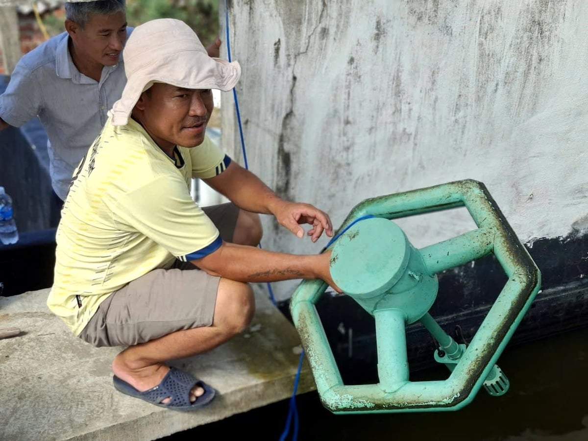 Ông Nguyễn Xuân Cần và thiết bị cảm biến thông minh đo trực tiếp các chỉ số như pH, nhiệt độ… trong ao nuôi tôm. Ảnh: L.A.