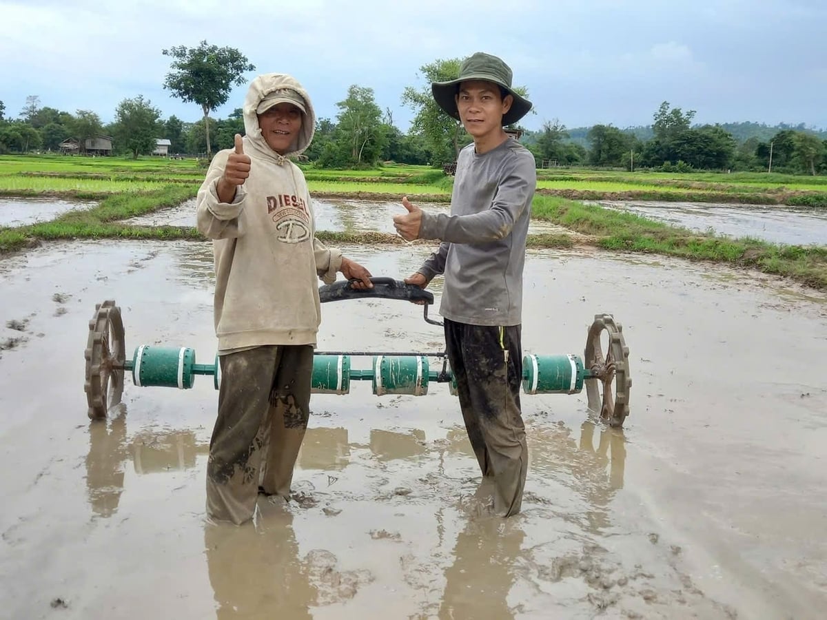 KS Nguyễn Cường, cán bộ kỹ thuật Trung tâm Khuyến nông Gia Lai (phải) trực tiếp hướng dân nông dân Lào cách gieo sạ lúa thay cho cấy như trước đây. Ảnh: V.Đ.T.
