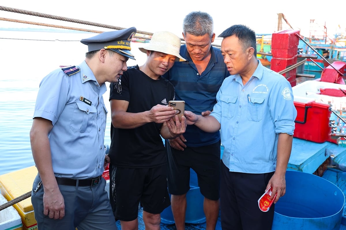 Lực lượng chức năng hướng dẫn người dân sử dụng nhật ký khai thác thủy sản điện tử. Ảnh: Thanh Nga.