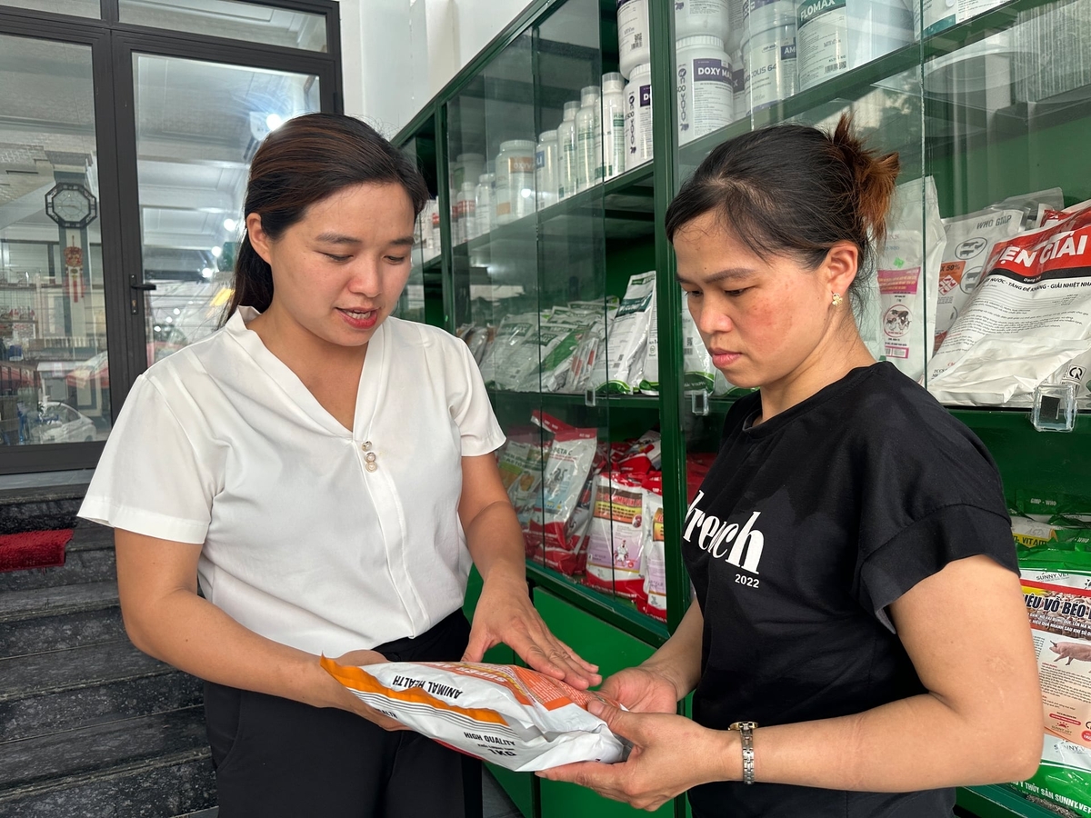Chị Nguyễn Thị Liễu (trái) hướng dẫn người dân sử dụng đúng các loại thuốc thú y. Ảnh: Quang Linh.