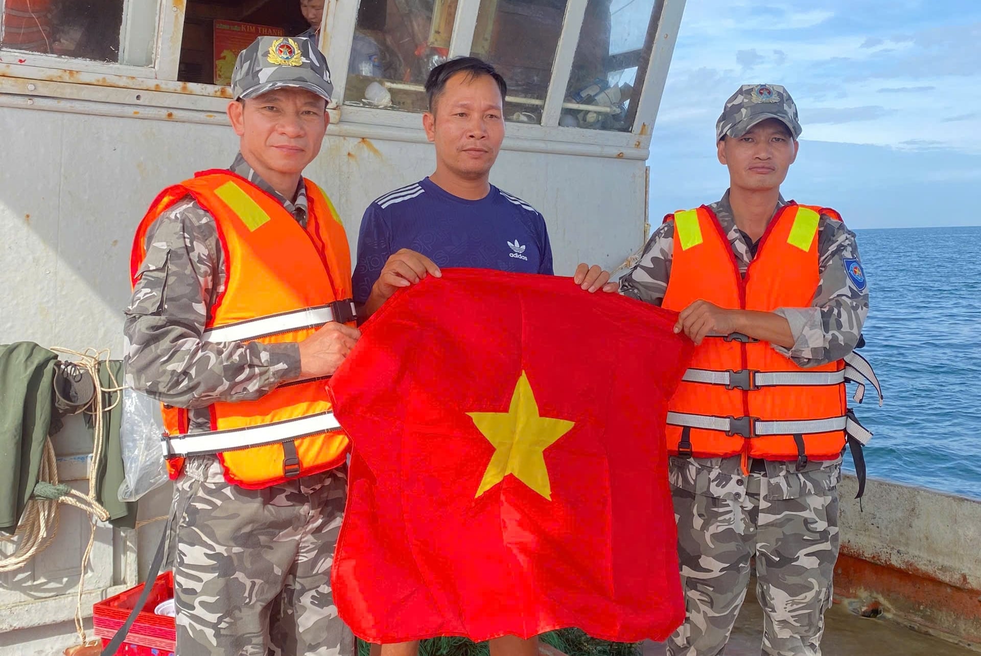 Cùng với việc tuần tra kiểm tra tàu cá, các lực lượng cũng chủ động tuyên truyền, phổ biến những quy định pháp luật về khai thác thủy sản, phát phao cứu sinh, tặng cờ Tổ quốc cho ngư dân. Ảnh: Nam Cận.