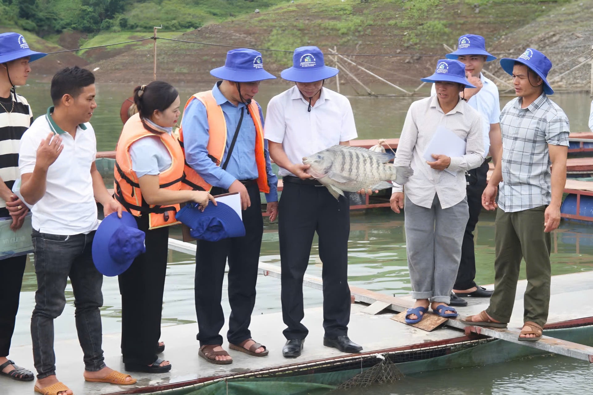Các đại biểu tham quan mô hình nuôi cá lồng trên lòng hồ thủy điện tại xã Quỳnh Nhai. Ảnh: Nguyễn Nga.